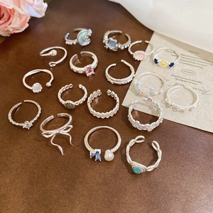 Flat lay of vintage silver ring set with pearls and crystals on dark brown background