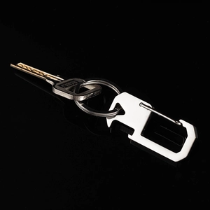Close-up of a 304 stainless steel multipurpose keychain with bottle opener on black surface