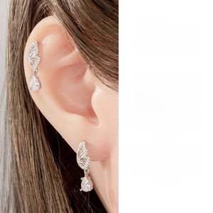 Détail de boucle d'oreille papillon avec pendentif goutte et zircons incrustés