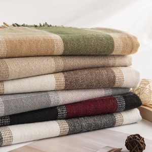 Stacked collection of plaid cashmere-feel scarves with fringe in various autumn colors