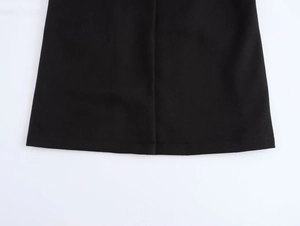 Close-up detail of the hemline and soft woven fabric texture on a black casual coat