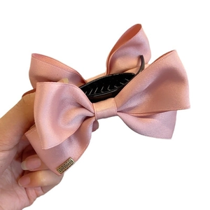 Pink satin bow hair claw clip with LOVEDAYS metal tag for bun hairstyle styling