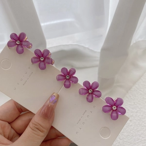 Detailed view of 5-piece set of purple resin flower hair clips with sparkling rhinestones