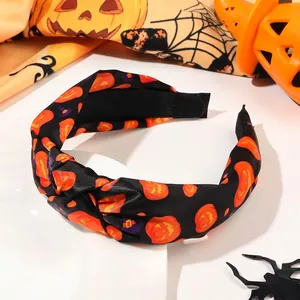 Detail of Halloween knotted headband with orange pumpkin print and wizard hat pattern