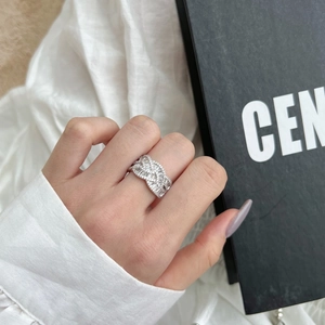 Macro detail of S925 sterling silver ring with pavé cubic zirconia in woven cross design