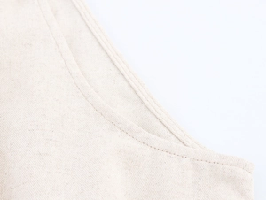 Makroaufnahme der beigen Baumwoll-Leinen-Stofftextur und feiner Saumstich-Details
