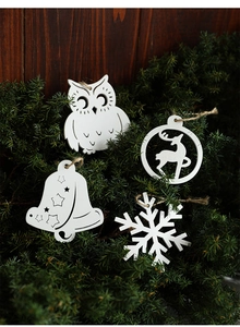 Detailed laser-cut white wooden Christmas ornaments with festive reindeer and snowflake shapes