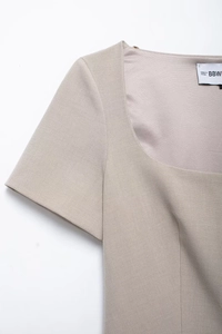 Detail of square neckline and short sleeves on beige vintage chic woven blouse top