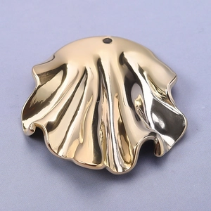 Close-up of golden stainless steel seashell pendant with smooth finish for DIY jewelry