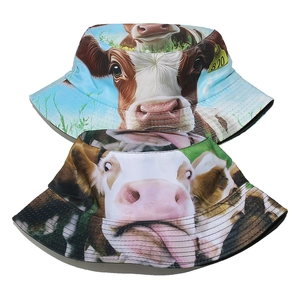 Detail view of two bucket hats with realistic cow print and funny expressions