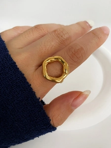 Detailed close-up of a 18K gold irregular wavy ring worn on a finger with minimalist style