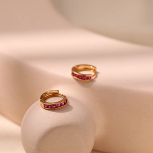 Close-up of gold plated hoop earrings with square-cut ruby red zircon stones inlay