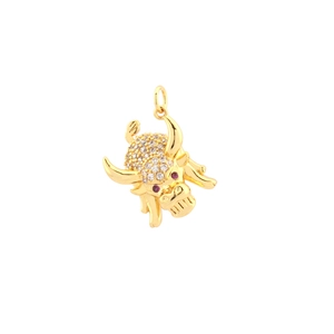 Detail of a golden bull head pendant with zircon stones and sparkling red gem eyes