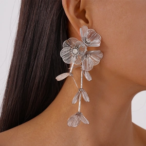 Close-up of a silver floral tassel earring with rhinestones worn by a model in profile