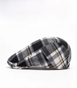 Side view detail of a classic black white and yellow plaid newsboy flat cap for outdoor use