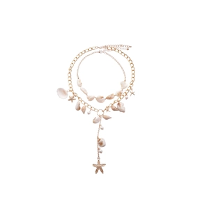 Bohemian gold layered necklace featuring starfish pendants, seashells, and pearls
