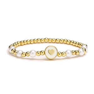 Bracelet cœur minimaliste composé de billes dorées et de perles blanches sur fond blanc