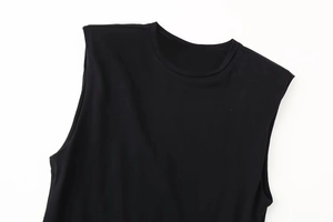 Detail of black slim-fit sleeveless dress with padded shoulders and knit texture