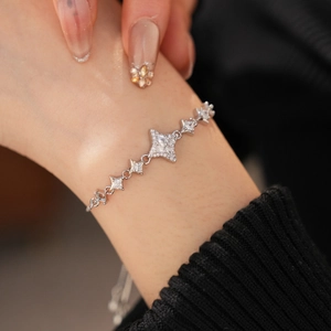Macro shot of star-shaped bracelet with cubic zirconia on a model's wrist with black sleeve