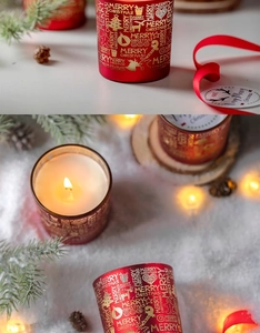 Makroaufnahme einer roten Duftkerze im Glas mit festlichem Golddekor Merry Christmas
