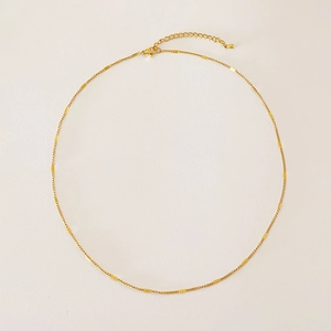 Detail view of the golden chain showing the adjustable extender and lobster clasp closure