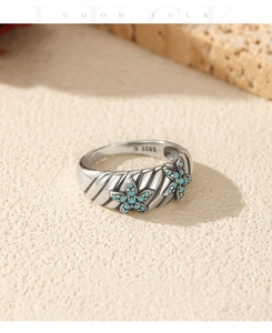 Detailed close-up of S925 silver ring featuring dual starfish with blue stones