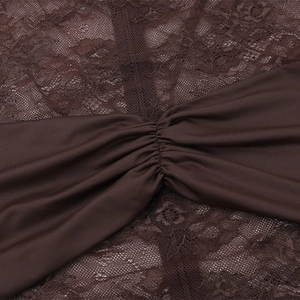 Macro detail of the delicate lace pattern and ruched fabric on the dark brown dress