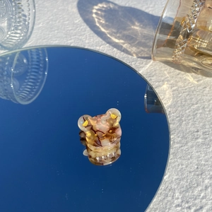 Détail d'une mini pince à cheveux ours en acétate ambre avec un petit accent de cœur doré