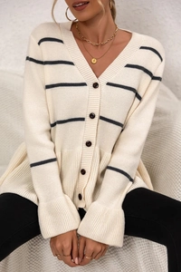 Close-up of cream knit cardigan featuring black horizontal stripes and v-neck button detail