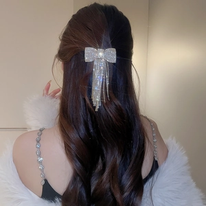 Détail d'une pince à cheveux nœud argentée avec pampille en cristal et franges élégantes