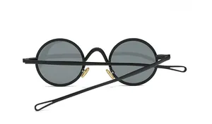 Detail der runden Retro-Sonnenbrille mit goldenen Nasenpads und hohlen Bügelenden in Tropfenform