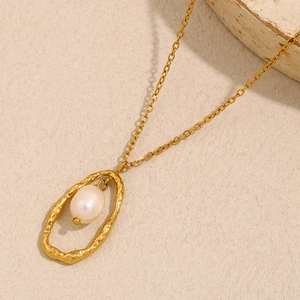 Détail du pendentif ovale plaqué or 18K avec perle blanche incrustée et texture irrégulière