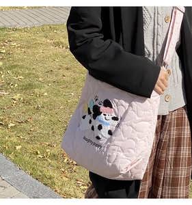 Quilted pink tote bag with puppy embroidery shown in outdoor lifestyle setting
