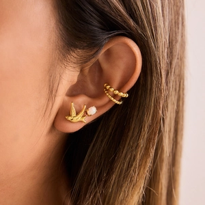 Elegant 18K gold-plated swallow earrings and beaded ear cuffs set on model's ear