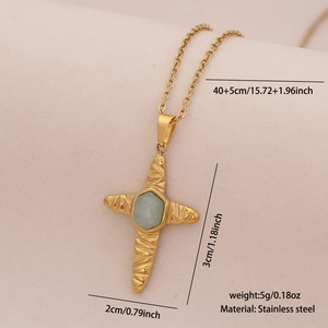 Detail of stainless steel cross necklace with a light blue gemstone on beige fabric