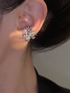Detailed view of silver zircon flower ear cuff worn on the cartilage for non-pierced ears