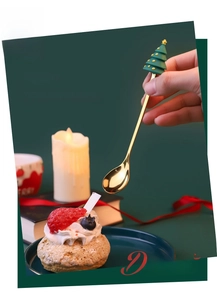 Detail of golden dessert spoon with green 3D Christmas tree silicone handle top