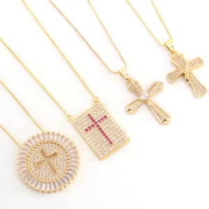 Golden cross necklaces with pink cubic zirconia stones on a clean white background