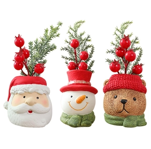 Detail of resin Christmas figures featuring Santa, snowman, and bear with pine branches