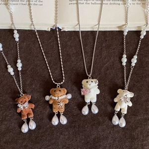 Détail de pendentifs ours floqués avec perles et nœuds en strass étincelants