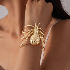 Detailed view of golden spider-shaped bracelet with sparkling rhinestones on the wrist