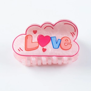 Vista detallada de una pinza para el pelo rosa con texto LOVE y detalles de corazones