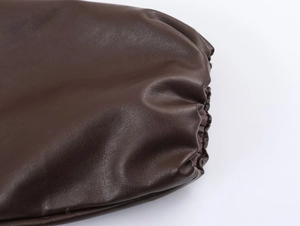 Close-up of deep brown faux leather texture with lychee grain and soft finish detail