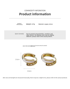 Détail de boucles d'oreilles créoles dorées avec zircon et émail blanc chic