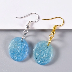 Blue resin earrings with silver glitter, oval shape and embossed letter M detail
