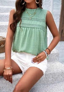 Detail of green sleeveless blouse with lace patchwork and pleated high collar design
