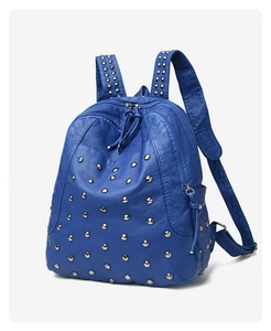 Detail of blue faux leather backpack with silver cone metal studs and pebbled texture