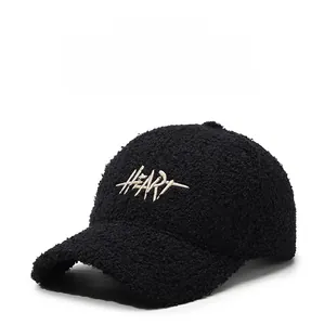 Detailed view of white HEART 3D embroidery on black faux shearling baseball cap