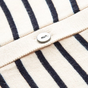 Vue macro du tissu d'un cardigan rayé avec rayures bleues et détail d'un bouton