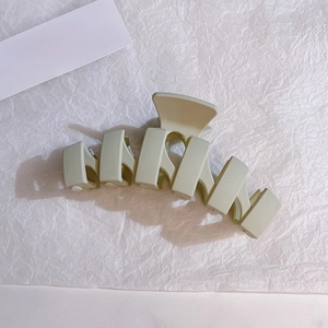 Close-up of minimalist cream beige large hair claw clip with geometric rectangle design